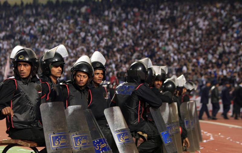 Egyptian riot police stand guard in Cairo Stadium during the first half of a match between Zamalek and Ismaili clubs in Cairo on February 1, 2012.  At least 73 people were killed in fan violence after a football match between Al-Ahly and Al-Masry clubs in the city of Port Said, the health ministry said, as Egypt struggled with a wave of incidents linked to poor security. AFP PHOTO/MAHMUD HAMS
 *** Local Caption ***  778613-01-08.jpg