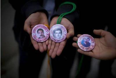 Rachid Ghannouchi's entourage hand out memorial medallions featuring images of An Nahda supporters who died in prison. Silvia Razgova / The National