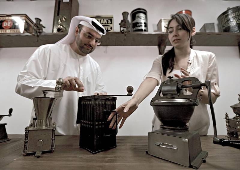 Khalid Al Mulla, the founder of the Coffee Museum, shows two German-made coffee grinders from the Second World War to Arezou Schulz, a project manager at the museum. Ravindranath K / The National