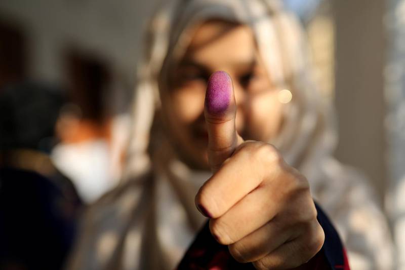 A woman displays her inked thumb after casting her vote at the general election in Dhaka. Reuters