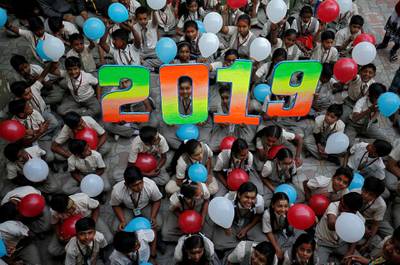 Schoolchildren hold balloons as they pose during celebrations to welcome the New Year at their school in Ahmedabad, India. Reuters