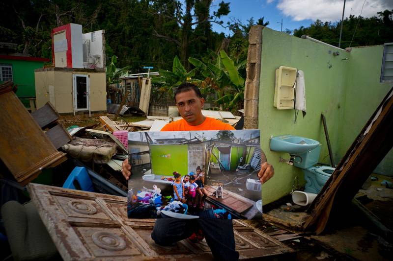 Arden Dragoni holds a printed photo taken on October 5, 2017. The unemployed construction worker and security guard is currently separated from his family while his wife and his children live in a subsidised apartment, and he lives with his father. "The hurricane brought us many calamities but my lesson was to value my family from my heart," said Dragoni.