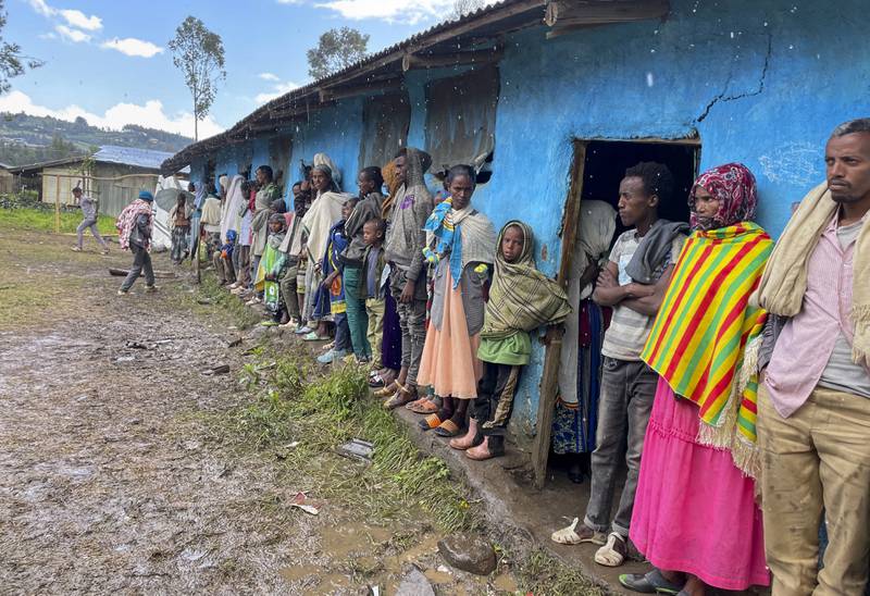 Displaced Amharas from different villages now controlled by Tigrayan forces in the North Gondar zone, shelter under an awning in the rain at a kindergarten school housing the internally-displaced, in Debark, in the Amhara region of northern Ethiopia Wednesday, Aug.  25, 2021.  AP