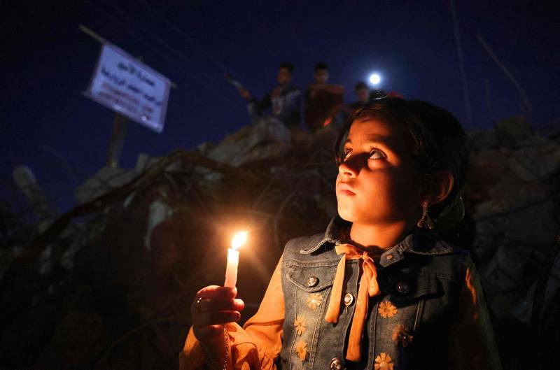 A Palestinian child attends a rally in Gaza city amid the ruins of houses destroyed by Israeli strikes. AFP