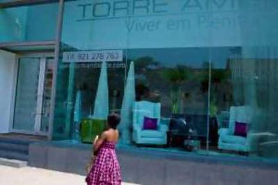 Luanda, Angola: May 28, 2010:  A woman walks past the showroom for the new luxury apartment building, Torre Ambiante, the slogan for the new building is "Viver em Plenitude" or "Live in Plentitude". Lauren Lancaster / The National