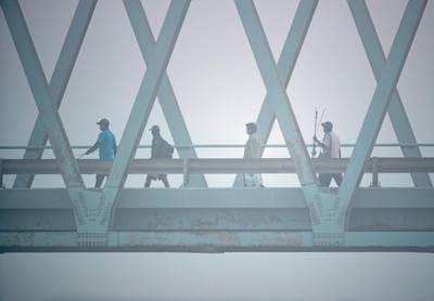 Anglers cross the Yas Iron Bridge in Abu Dhabi to get to their fishing spot amidst the fog on June 4th, 2021. Victor Besa / The National.