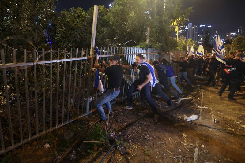 Israeli protesters dislodge a fence. AFP