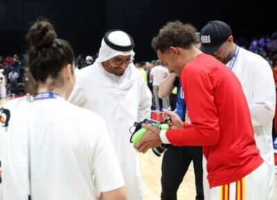 Mohamed Khalifa Al Mubarak, chairman of DCT Abu Dhabi, is given a shoe signed by Atlanta Hawks player Trae Young. Chris Whiteoak / The National
