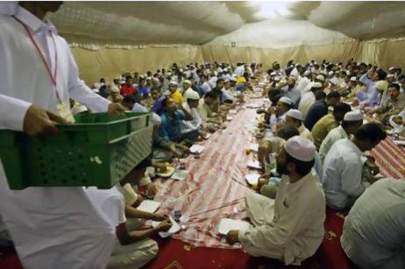 Labourers break their fast in a Red Crescent tent after the first day of Ramadan in Mussaffah in 2009. The charity has historically given out about 30,000 iftar meals over the course of the month. Jaime Puebla / The National
