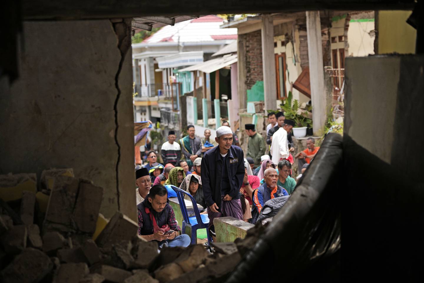 Men prepare to perform Friday prayers outside a damaged building in Cianjur, West Java. AP