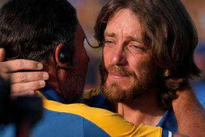 An emotional Tommy Fleetwood, right, celebrates on the 17th green after winning his singles match at the Ryder Cup. AP