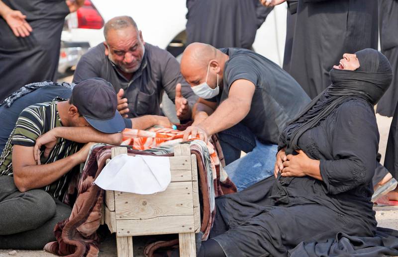 An Iraqi family mourns around the coffin of a relative, who died of the novel coronavirus, during a reburial ceremony at the vast Wadi al-Salam cemetery in the Shiite holy city of Najaf on September 11, 2020. - For months, families of those who died after contracting Covid-19 were barred from taking the body back to bury in family tombs, for fear their bodies could still spread the virus.
Instead, the authorities established a "coronavirus cemetery" in a plot of desert, where volunteers in protective gear carefully buried victims spaced five metres (16 feet) apart.
But on September 7, Iraqi authorities announced they would permit those who died after contracting Covid-19 to be reburied in the cemetery of their family's choice. (Photo by - / AFP)