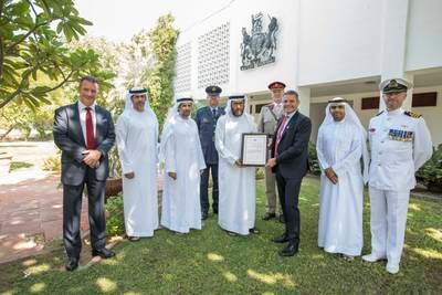 Simon Penney, British Consul General to Dubai and the Northern Emirates, presents a plaque of appreciation to the sons of Muhammad bin Lahej for his role during the Second World War. Ruel Pableo for The National
