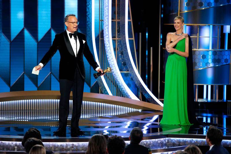 77th Golden Globe Awards - Show - Beverly Hills, California, U.S., January 5, 2020 - Tom Hanks accepts the Cecil B. DeMille Award as Charlize Theron looks on.   Paul Drinkwater/NBC Universal/Handout via REUTERS For editorial use only. Additional clearance required for commercial or promotional use, contact your local office for assistance. Any commercial or promotional use of NBCUniversal content requires NBCUniversal's prior written consent. No book publishing without prior approval. NO SALES. NO ARCHIVES.