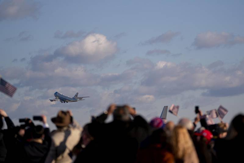 Supporters hold American flags as Air Force One, carrying US President Donald Trump, departs during a farewell ceremony at Joint Base Andrews, Maryland. Bloomberg