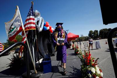 A Compton Early College High School graduating pupil leaves a stage after collecting her diploma during a drive-through graduating ceremony. Reuters