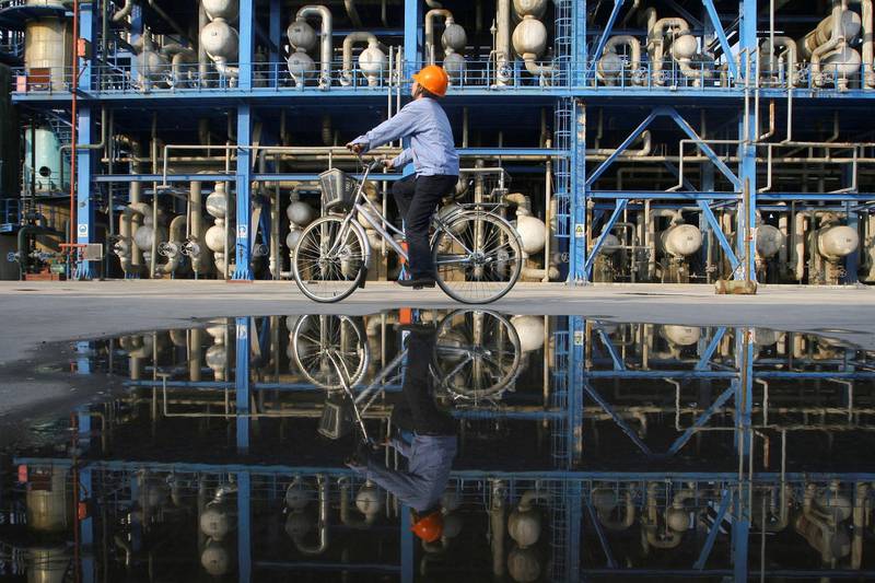 FILE PHOTO: An engineer on a bicycle checks pipelines at an oil refinery of China National Petroleum Corp (CNPC), in Lanzhou, Gansu province, China April 21, 2008.  REUTERS/Stringer/File Photo   CHINA OUT.