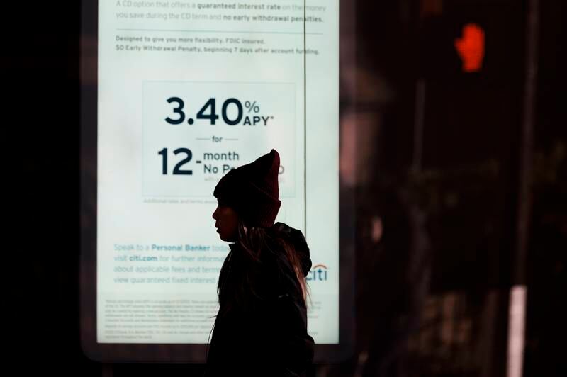 A person walks by a sign showing interest rates at a bank in New York.     EPA 