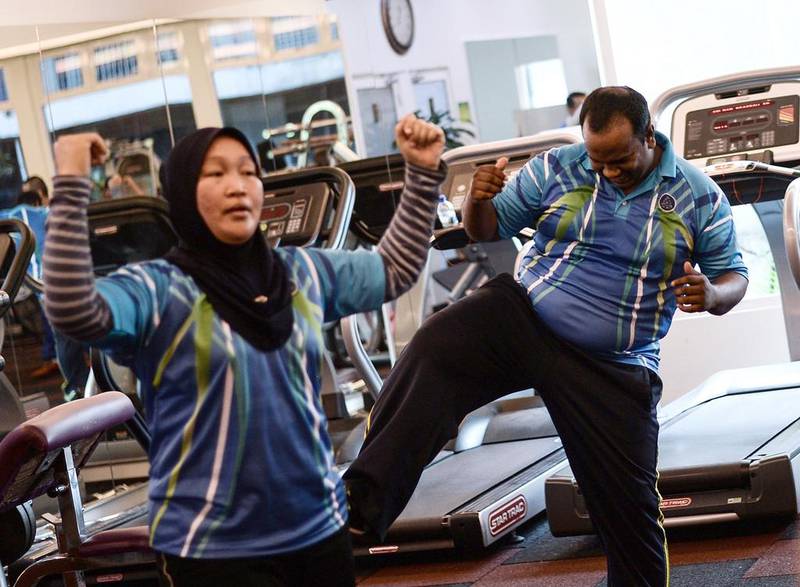 Malaysian police officer Suresh Mariah, right, exercising as he takes part in the special weight-loss fitness programme at the police headquarters in Kuala Lumpur. Suresh is among thousands of Malaysian officers who have been ordered to lose weight amid concern that fast-expanding waistlines could limit their crime-fighting abilities.  Manan Vatsyayana/AFP Photo