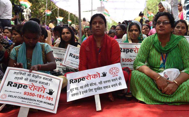 Indian women hold placards as they sit during a protest organised by Delhi Commission for Women in New Delhi, India, on April 13, 2018. Money Sharma / AFP