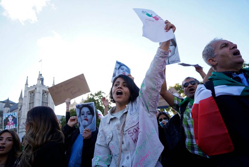 People chant slogans and hold up images of Mahsa Amini during a protest in London in solidarity with those in Iran. AFP