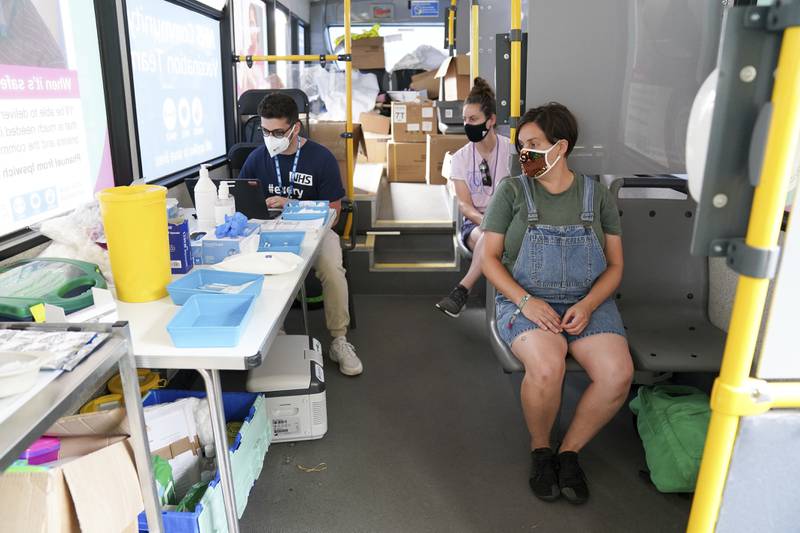 Festival-goers wait to receive a vaccine on board a bus at the Latitude Festival.