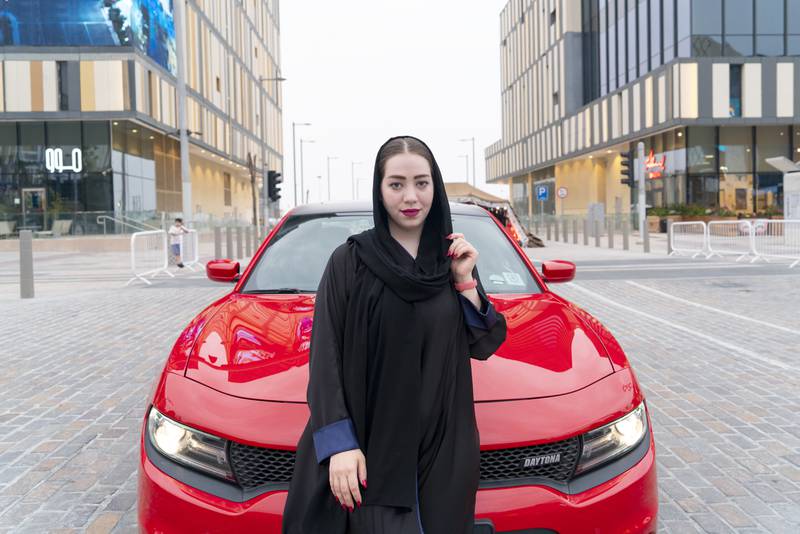 Car influencer Bayan Homsi with her red Dodge