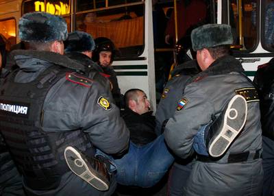 Policemen detain an activist during a rally to protest against the results of the parliamentary elections and the policies conducted by Russian authorities in Moscow December 6, 2011. Russians took to the streets of Moscow for the second successive day on Tuesday to demand an end to Prime Minister Vladimir Putin's 12-year rule, but riot police blocked their way and hundreds of pro-Kremlin youths tried to spoil the protest.  REUTERS/Mikhail Voskresensky  (RUSSIA - Tags: POLITICS ELECTIONS CIVIL UNREST CRIME LAW) *** Local Caption ***  MOS49_RUSSIA-ELECTI_1206_11.JPG
