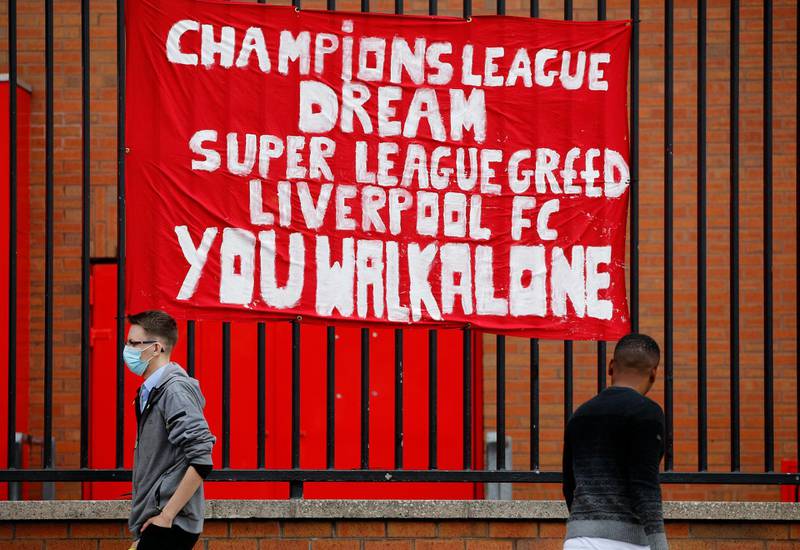 Soccer Football - Twelve of Europe's top football clubs launch a breakaway Super League - Liverpool, Britain - April 21, 2021   People walk past anti Super League banners outside Anfield as twelve of Europe's top football clubs launch a breakaway REUTERS/Phil Noble