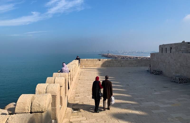 A couple walking by the 15th century Qaitbay castle, where authorities have placed concrete barriers to protect the key landmark in the Mediterranean city of Alexandria from rising sea levels. Reuters