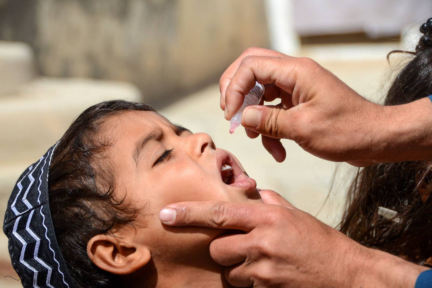 A health worker administers polio vaccine drops to a child on May 23 during a polio vaccination campaign in Kandahar, Afghanistan. AFP