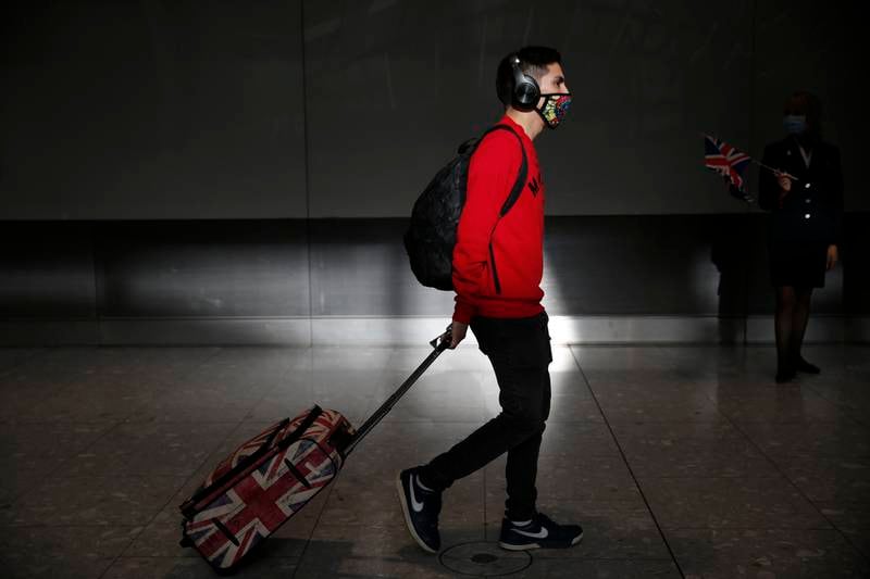A man wheels a Union Jack suitcase through the international arrival gate at Heathrow Airport in London.  Getty Images