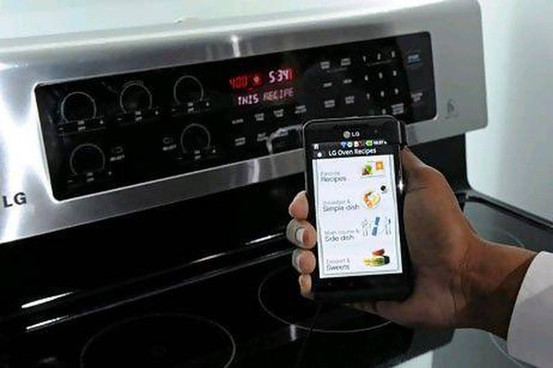 A smartphone sends instructions to an oven using LG's Smart ThinQ technology. Ethan Miller / Getty