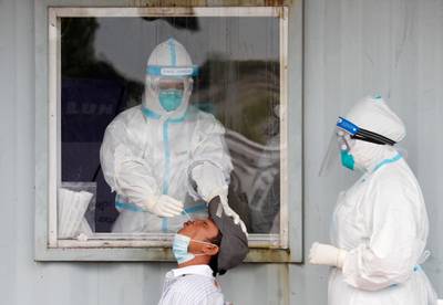 Health workers wear personal protective equipment as they take a Covid-19 swab from a lorry driver at the Yangon-Mandalay expressway in Yangon, Myanmar. EPA
