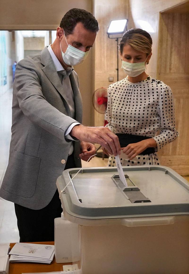 (FILES) In this file handout picture released by the Syrian Presidency Facebook page on July 19, 2020, shows Syrian President Bashar al-Assad and his wife Asma voting at a polling station in the capital Damascus, during the parliamentary elections. The Syrian president and his wife have tested positive for COVID-19 after experiencing mild symptoms, the presidency said on March 8, 2021. - RESTRICTED TO EDITORIAL USE - MANDATORY CREDIT "AFP PHOTO / Syrian Presidency Facebook page " - NO MARKETING NO ADVERTISING CAMPAIGNS - DISTRIBUTED AS A SERVICE TO CLIENTS
 / AFP / Syrian Presidency Facebook page / - / RESTRICTED TO EDITORIAL USE - MANDATORY CREDIT "AFP PHOTO / Syrian Presidency Facebook page " - NO MARKETING NO ADVERTISING CAMPAIGNS - DISTRIBUTED AS A SERVICE TO CLIENTS
