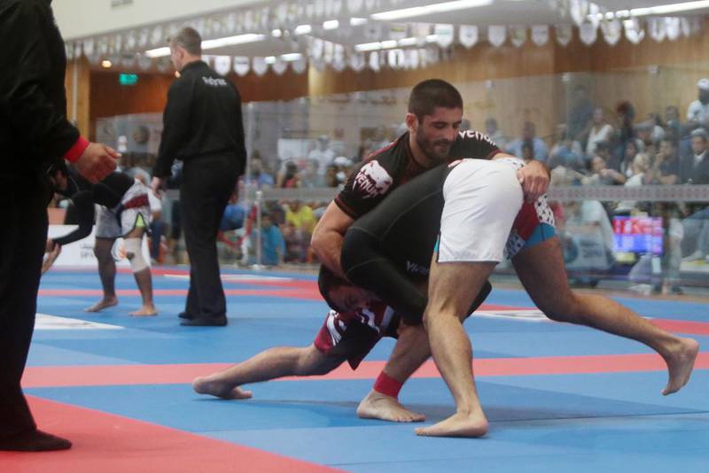 Gadzhimirza Osmanov of Russia, left, fights Hamdan Al Balooshi of UAE during their blue 80kg quarter-final match in the Ramadan Cup during the AFOCH 19th Open Sports Festival at the Armed Forces Officers Club in Abu Dhabi on Saturday. Christopher Pike / The National