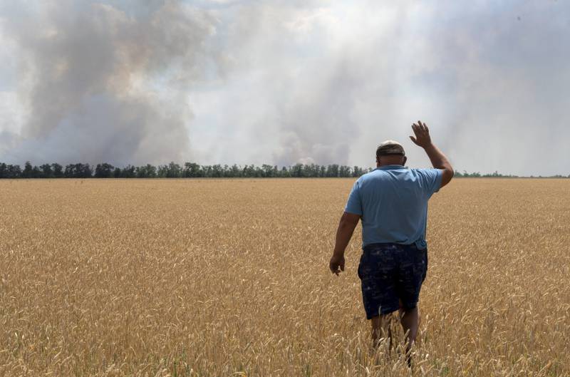 A farmer looks on as his field burns amid fighting in the Dnipropetrovsk region of Ukraine, on July 4.  AP