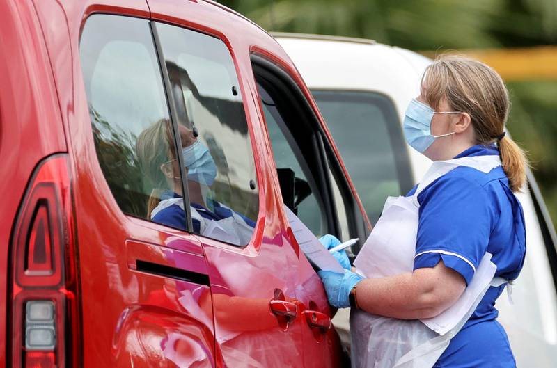 A medical worker approaches a car in a drive-thru testing centre, following a spike in cases of the coronavirus disease (COVID-19) to visitors of a pub in Stone, Britain, July 29, 2020. REUTERS/Carl Recine