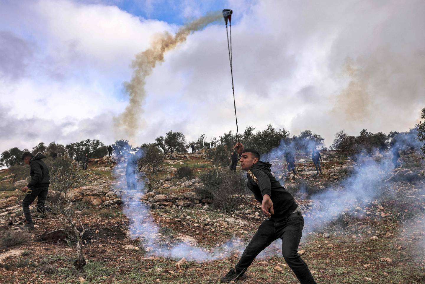 A Palestinian uses a slingshot to return a tear gas canister at Israeli security forces, as a rally against settlements in Beita in the occupied West Bank turned violent. AFP
