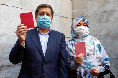 Presidential candidate Abdolnasser Hemmati and his wife hold documents before voting during Iran's presidential elections at a polling station in Tehran. Reuters