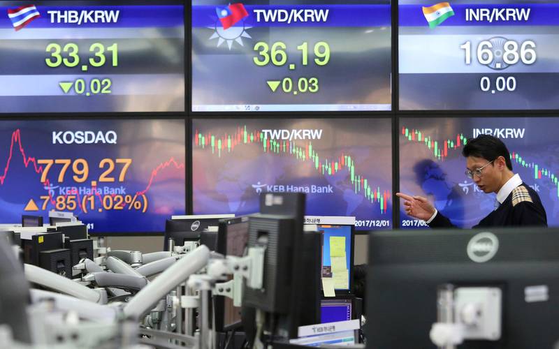 A currency trader works at the foreign exchange dealing room of the KEB Hana Bank headquarters in Seoul, South Korea, Friday, Dec. 1, 2017. Asian stock markets were marginally higher Friday, after an overnight recovery of technology stocks on Wall Street. An agreement among key crude exporting countries to extend oil output cuts boosted sentiment.  (AP Photo/Ahn Young-joon)