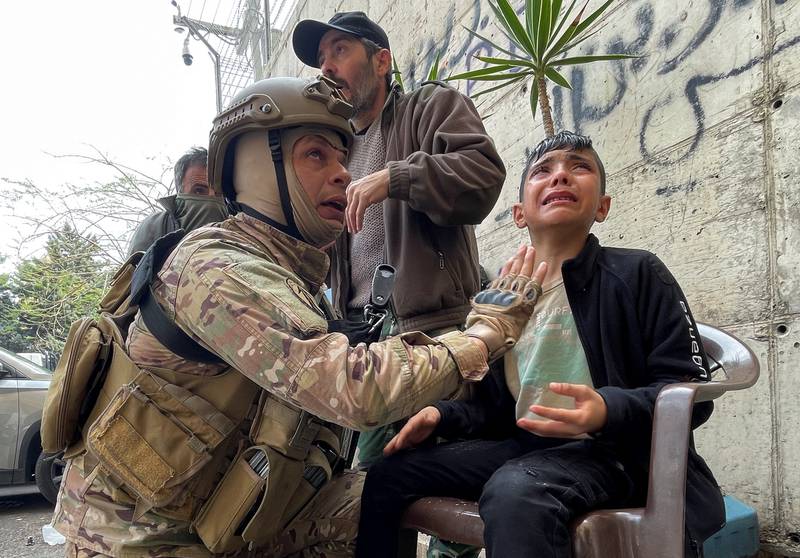 A Lebanese soldier assists a boy affected by tear gas. Reuters