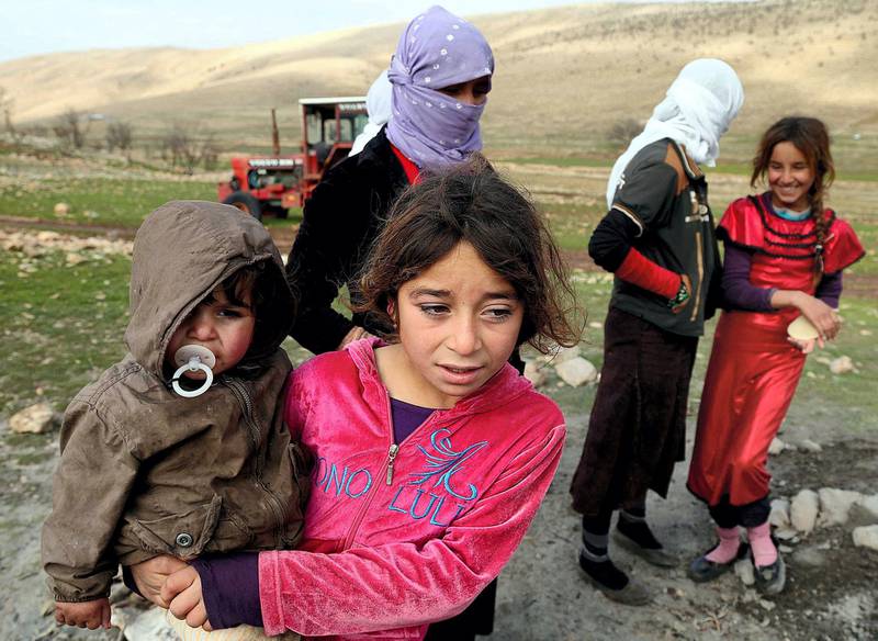 SINJAR, IRAQ - DECEMBER 20: Yezidis, fled from Islamic State of Iraq and Levant (ISIL) forces' attacks on their home town Sinjar, stay in harsh conditions as the winter starts, in a valley of western Sinjar Mountain in Sinjar district of Mosul, Irak on December 20, 2014. Yezidi women and children are seen out side of the tents. (Photo by Emrah Yorulmaz/Anadolu Agency/Getty Images)