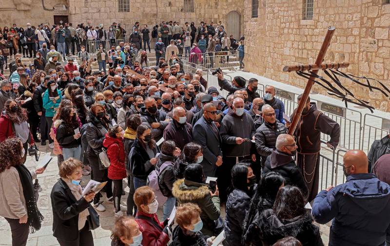 Christian worshippers reach the Church of the Holy Sepulchre in Jerusalem's Old City during the Good Friday procession on April 2, 2021.  AFP