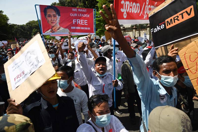 Protesters hold up signs during a demonstration against the military coup in front of the Chinese embassy in Yangon. AFP