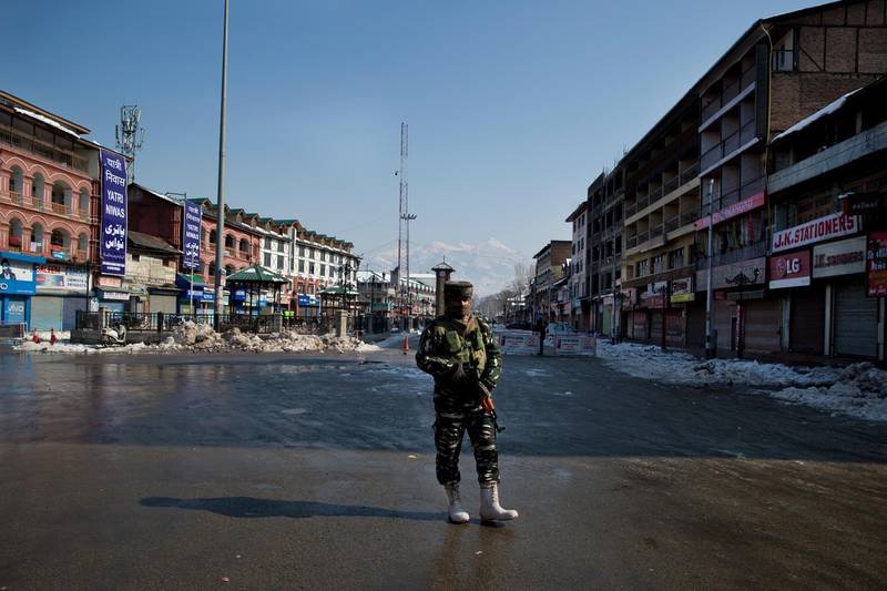 An Indian paramilitary solider stands guard near a temporary checkpoint during a strike in Srinagar, Indian controlled Kashmir, Saturday, Feb. 9, 2019. Restriction on the movement of vehicles were imposed protectively in parts of Srinagar as separatist groups called for a strike on the anniversary of execution of Afzal Guru, a Kashmiri who was convicted and given death sentence for his role in the 2001 attack on Indian Parliament. (AP Photo/Dar Yasin)