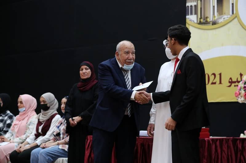 Ibraheem Barakeh, director of the Al Shola schools group hands over a cash prize to a high-achieving pupil. All pictures by Chris Whiteoak / The National