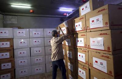 Workers unload boxes of Chinese medical supplies in Damascus, Syria.  EPA