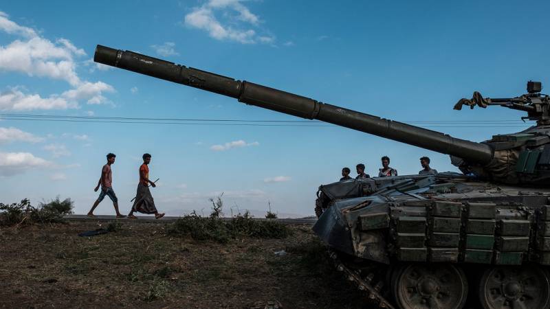 Youths walk next to the wreckage of tank south of the town of Mehoni, Ethiopia. AFP