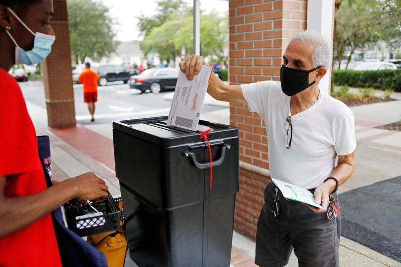 Florida resident Valentine Lugo casts his mail-in ballot at the Winter Garden Library polling station as early voting begins ahead of the election in Orlando, Florida, U.S. October 19, 2020.  REUTERS/Octavio Jones